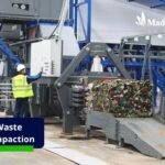 Modern industrial facility transitioning from manual to mechanical waste compaction
