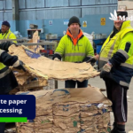 Waste paper processing with workers sorting used paper and cardboard